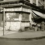 "Lower East Side: Abandoned corner food store, market in background. 1934-1945."